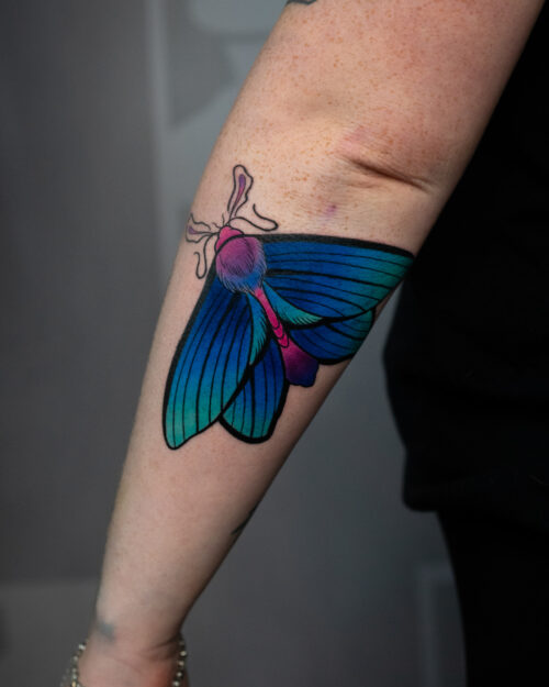 Neotradycyjny tatuaż przedstawiający owada, wykonany przez Adriana w studiu INK-OGNITO Tattoo Rybnik. Wzór o mocnych konturach i kolorowym wypełnieniu, łączący klasyczne elementy z nowoczesnym stylem.