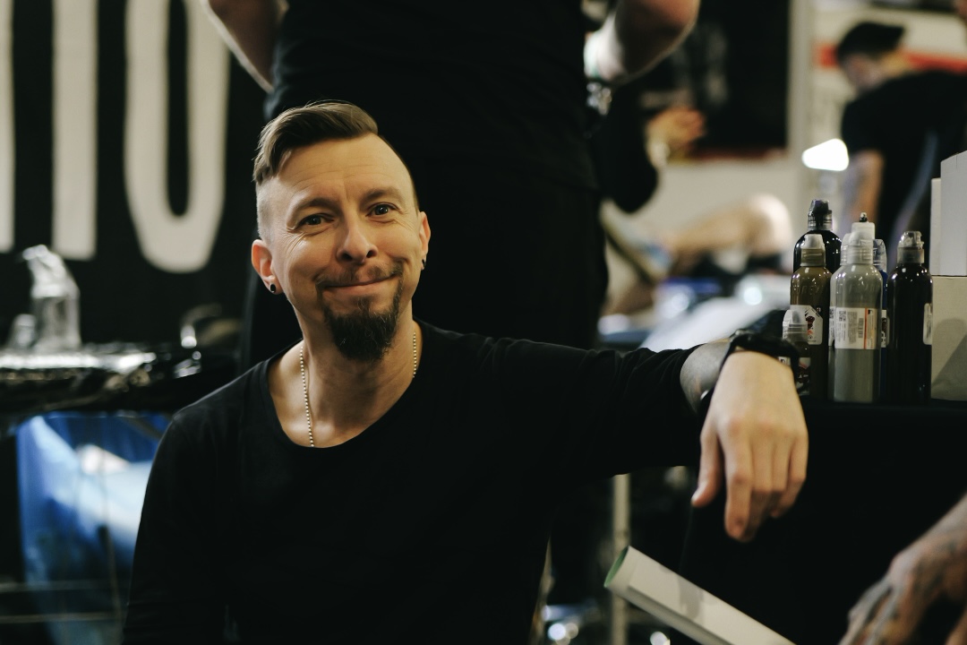 Zdjęcia z Tattoofest w Krakowie przedstawiające jednego z artystów.